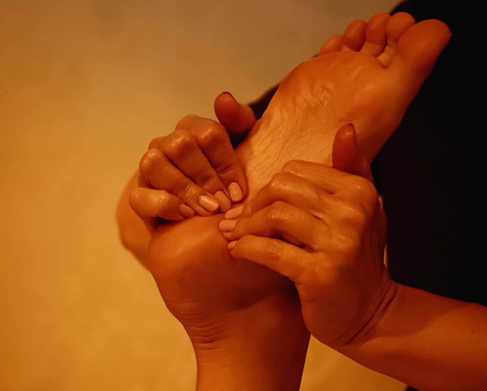 A woman's foot is being massaged by another person.